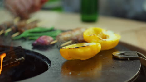 unknown guy cooking food on bbq grill outside. yellow bell pepper on grid