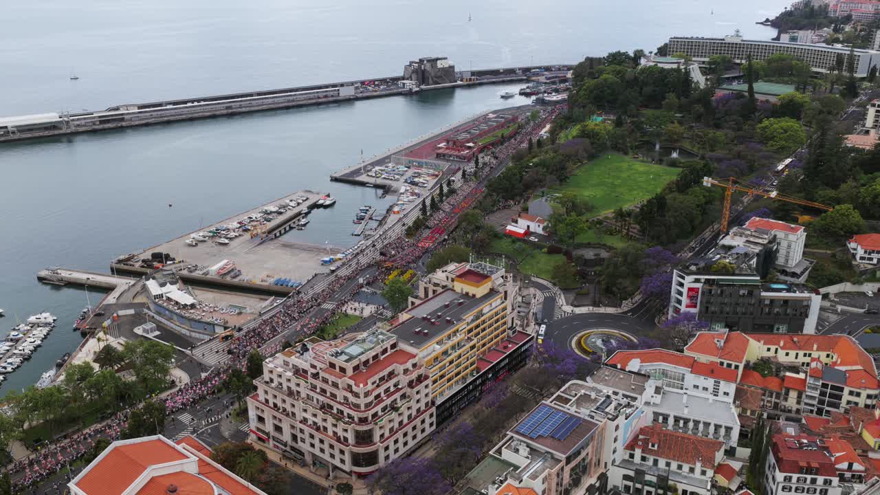 Aerial view of a crowd walking near the harbor in Funchal, Madeira, Portugal, during a cloudy day