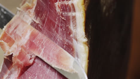 Cut-off-an-appetizing-piece-of-jamon---traditional-spanish-food-and-delicacy