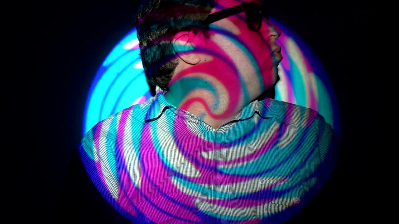 Portrait of a fat man in a multicolored light beam.