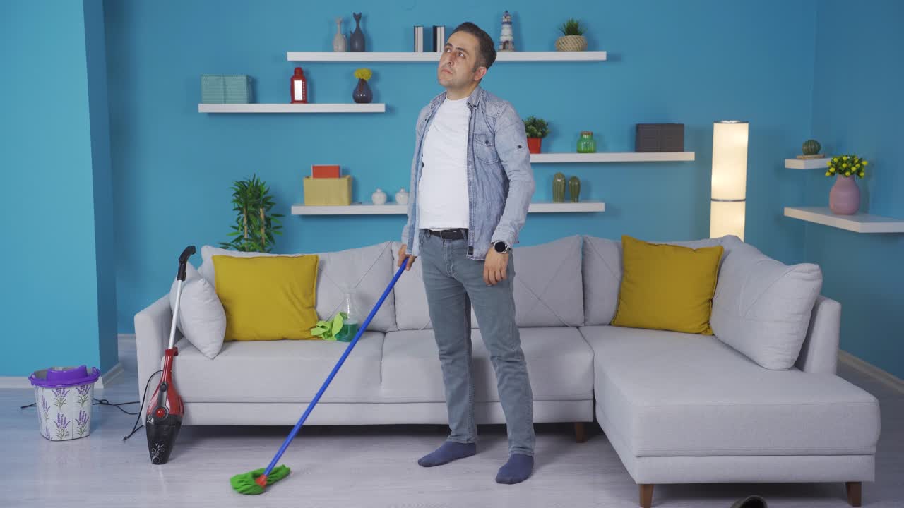 el hombre pensativo limpia la casa.