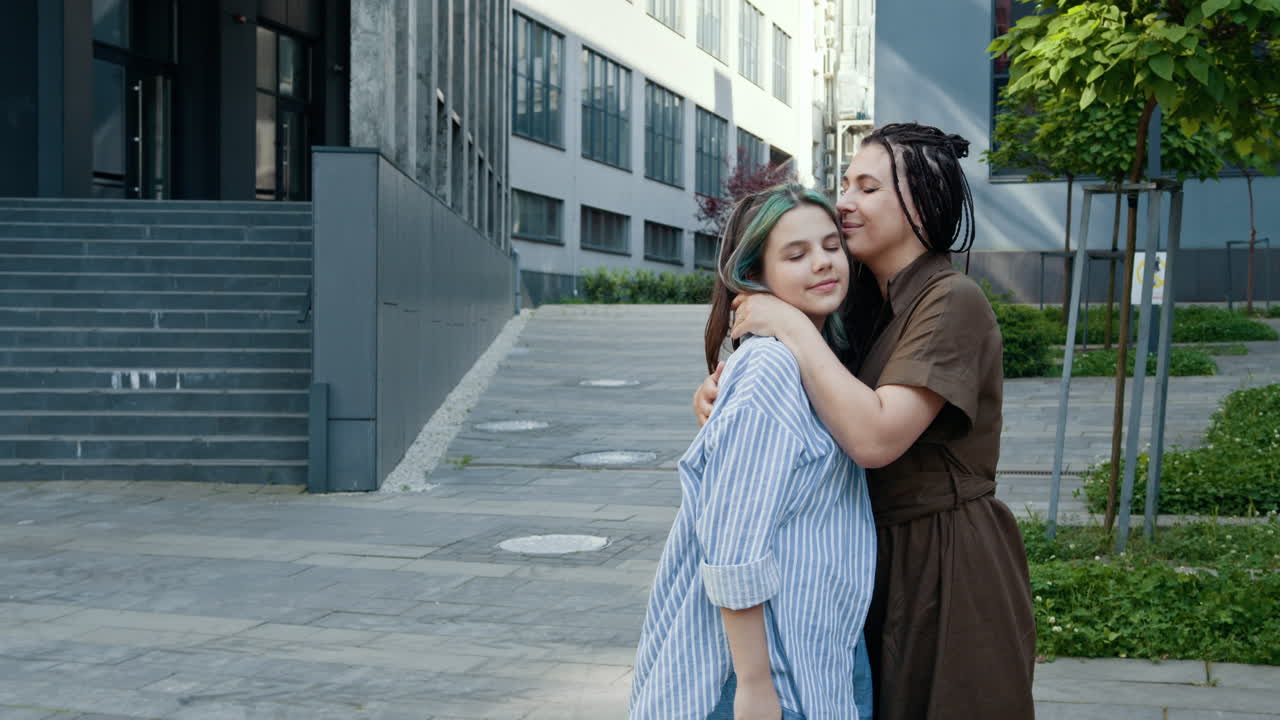 madre e hija abrazándose en la ciudad