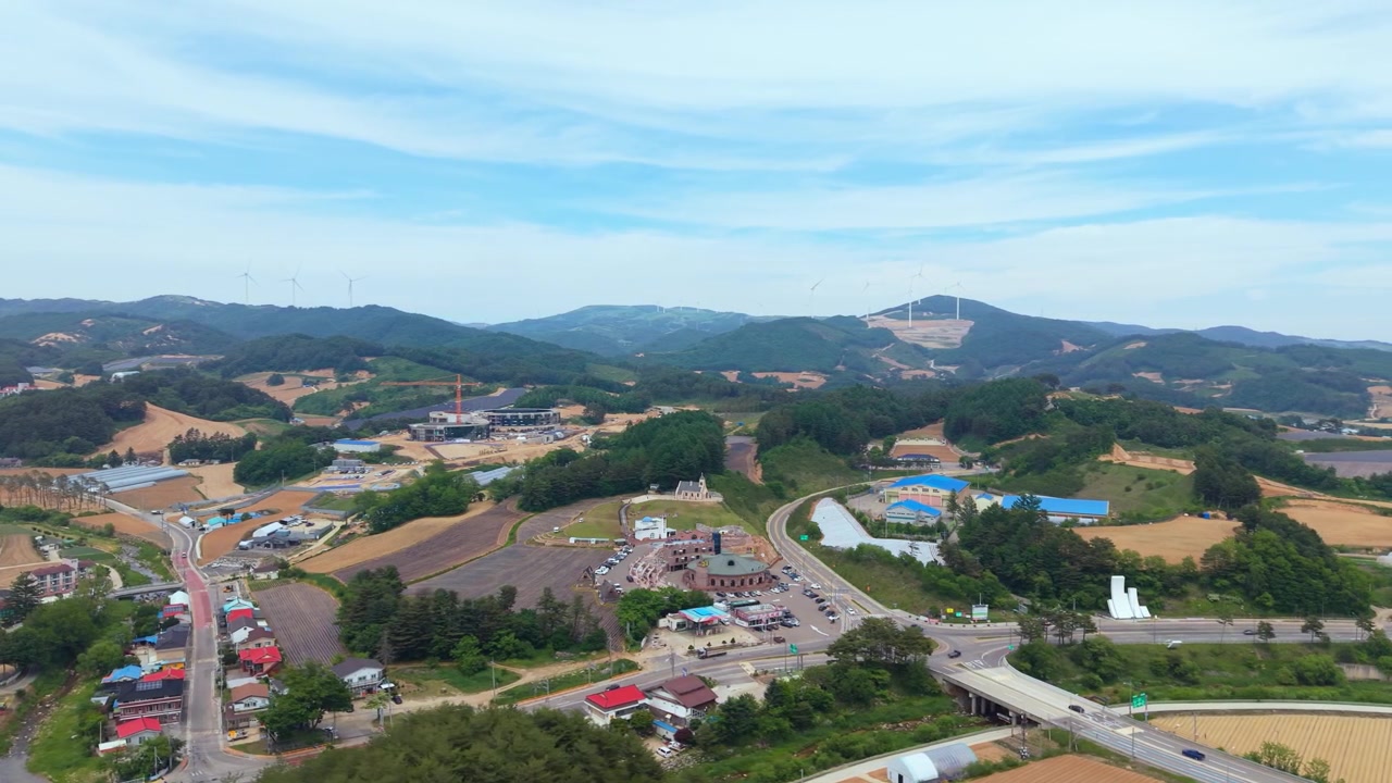 大関嶺のシルバーボール教会と山間部の田園風景を高高度から空撮した景色