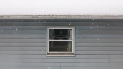Statische-Aufnahme,-Die-Das-Fenster-Des-Hauses-Zeigt,-Während-Schneeflocken-Im-Winter-Vom-Himmel-Fallen