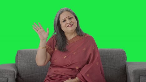 Happy-Indian-old-woman-saying-Hello-and-waving-hand-Green-screen