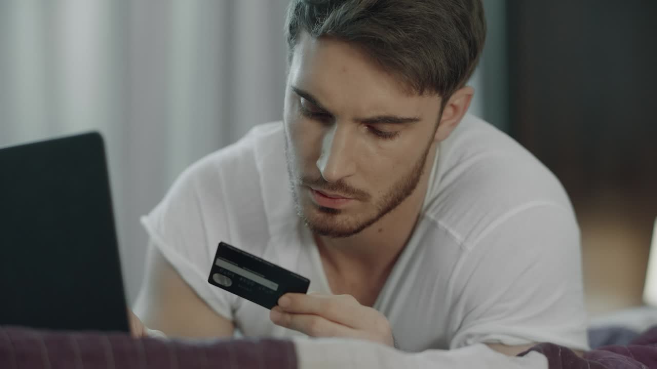Uomo che usa la carta di credito per un pagamento online al computer. Acquisto tecnologico.