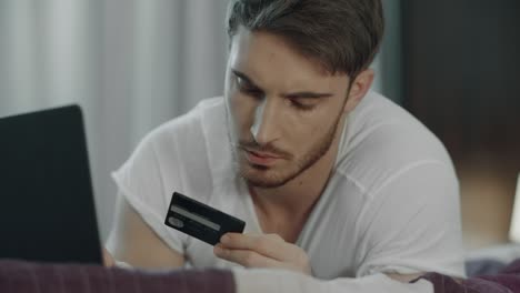 hombre que usa tarjeta de crédito para pagar en línea en la computadora. compra de tecnología