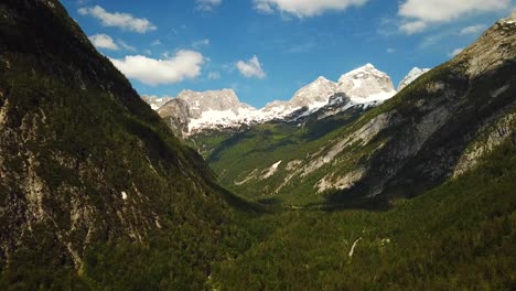 Forward-drone-shot-of-slovenian-mountains,-on-a-sunny-day-with-some-clouds