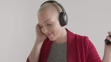 female model wearing a blazer listening to music on headphones