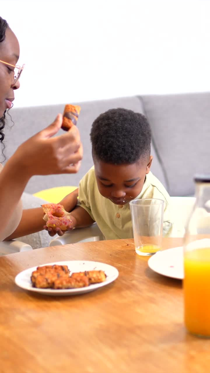 Child Enjoying a Donut at Breakfast with Family