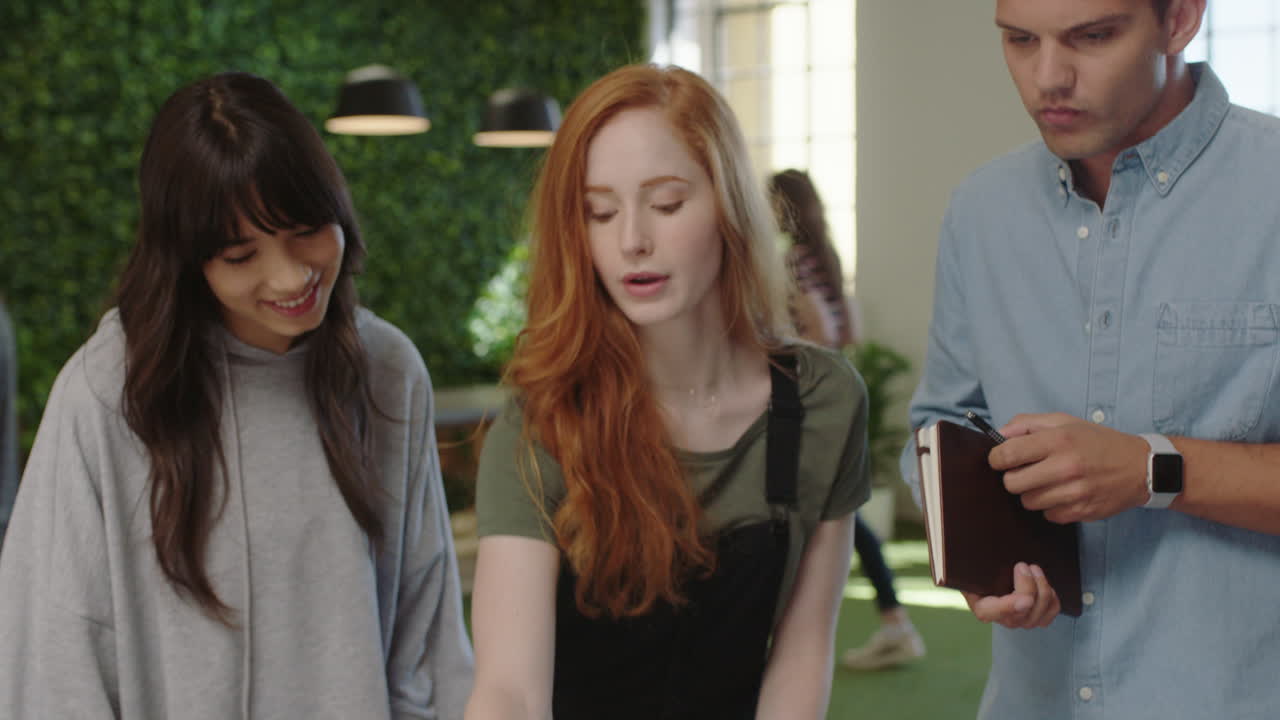 다민족 사업가 들 이 창의적 인 팀 리더 여성 들 이 아이디어 를 공유 하고 협력 하는 것 을 즐기는 동료 들 이 사무실 에서 노트북 을 사용 하여 함께 일 하는 것