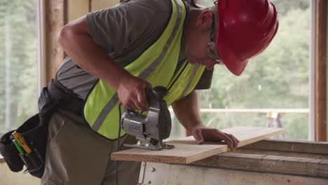 construction worker cutting wood with jigsaw