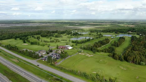 Gran-Vista-Aérea-De-Un-Campo-De-Golf-Ubicado-En-Un-Bosque-En-Un-Día-Nublado