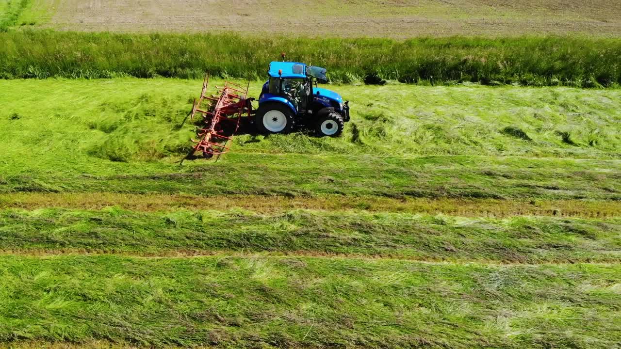 tedder en acción filmado desde arriba durante la cosecha de heno en europa