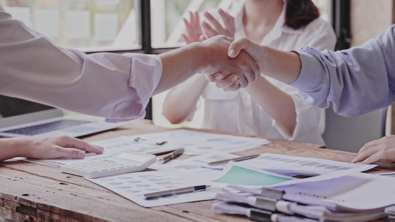 ¡alegre de trabajar con usted! joven de moda en ropa casual inteligente tomándose de la mano y sonriendo mientras trabaja en una oficina creativa.