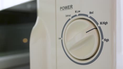 man adjusting the power setting on a microwave oven