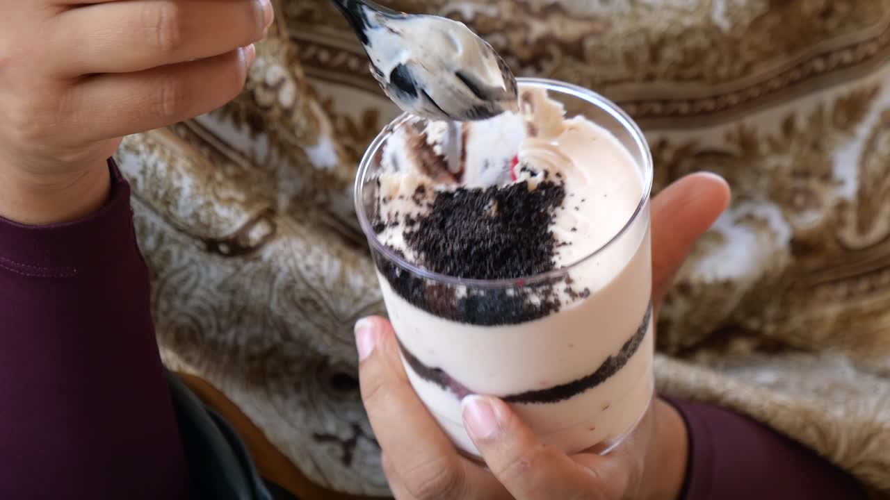 Persona che mangia un dessert parfait a strati