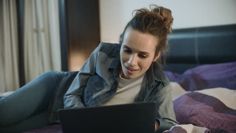 mujer feliz mirando la computadora portátil en casa