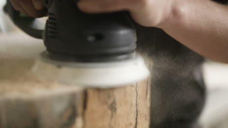 professional carpenter grinds wood in workshop 3