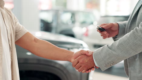 car salesman handing over car keys to customer