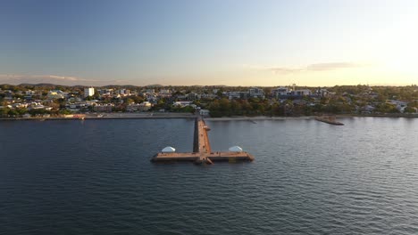 aerial shot of a jetty at sunset with numerous people walking, fishing, running, walking their dogs and kids