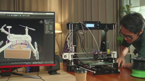 Asian Engineer Work On 3D Printer Printing And Personal Computer, Screen Shows Cad Software With 3D Prototype Of Drone Delivery