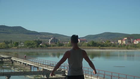 parkour professional walking while showing back muscle and looking in the beautiful scenery - wide shot