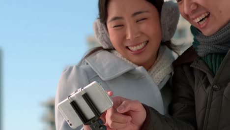 Loving-Asian-couple-in-winter-clothes-taking-selfies