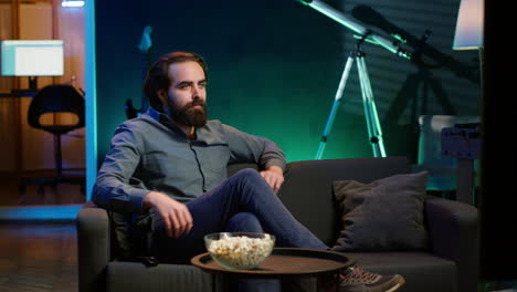 hombre en casa viendo una película interesante en la televisión