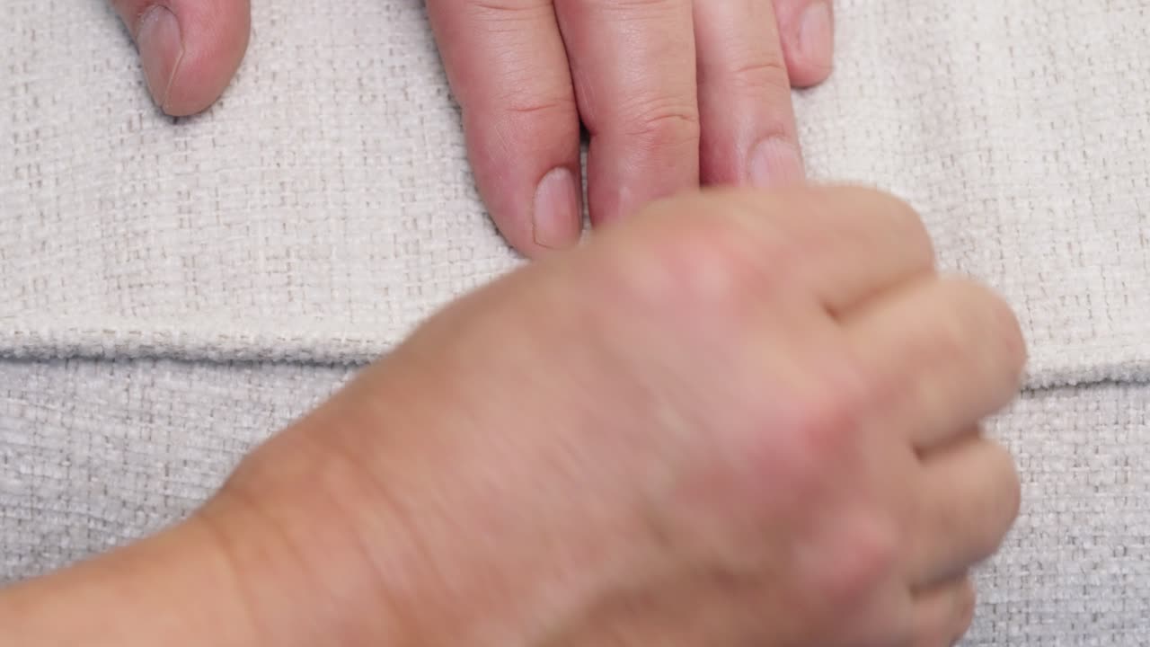 Hands stitch open pillow seam closed using curved needle and strong thread