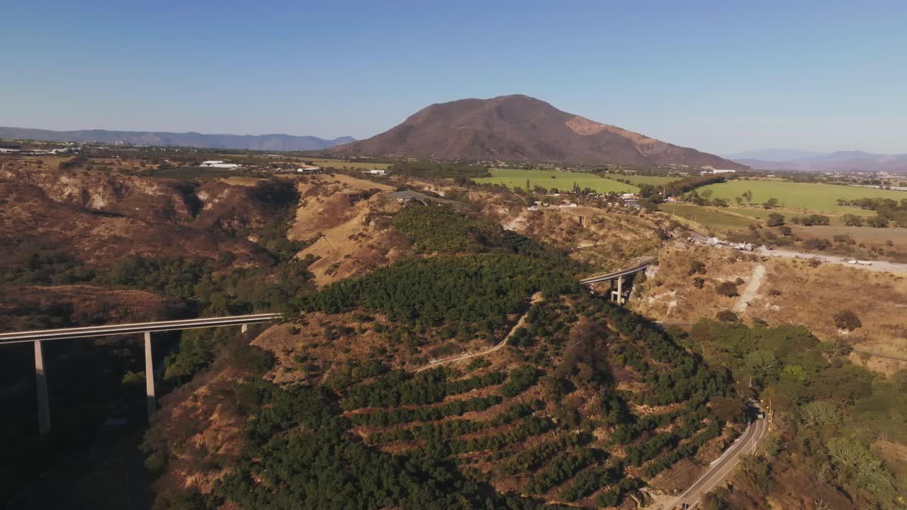 멕시코 할리스코의 푸엔테 아텐키케 도로 다리 근처 계곡에 있는 아보카도 과수원 위를 날다