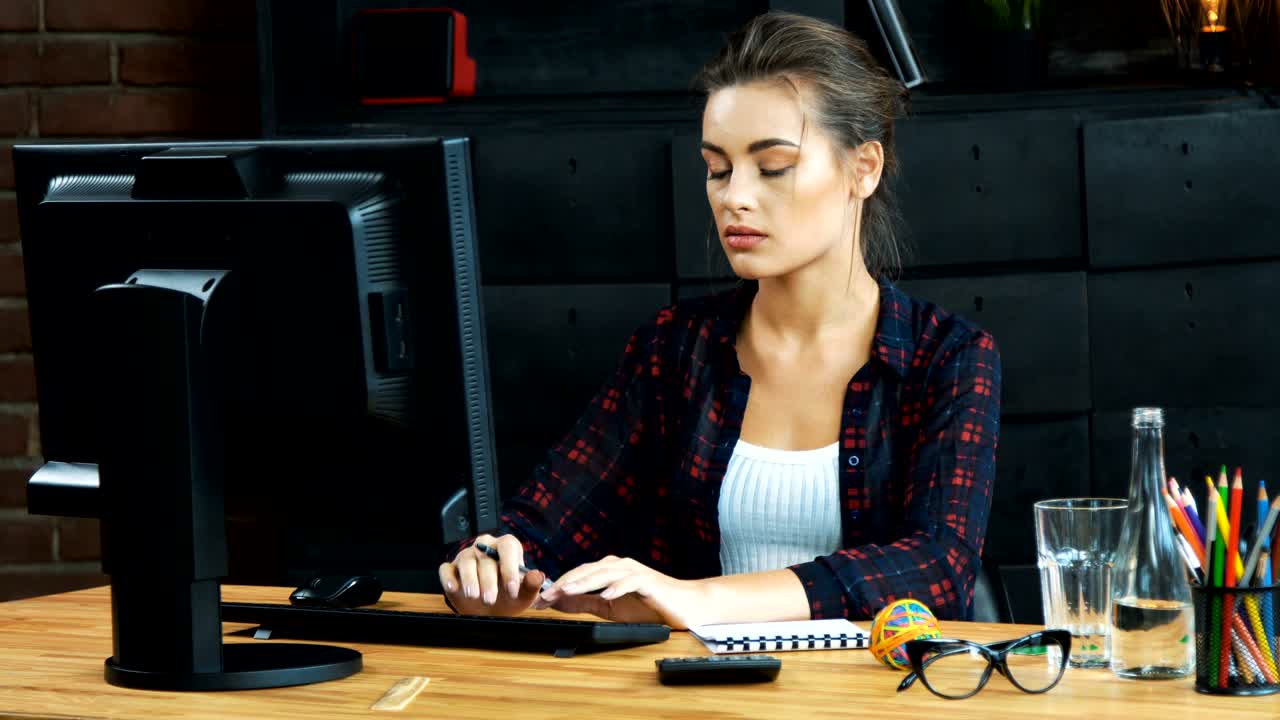 una chica hermosa trabajando con una computadora.