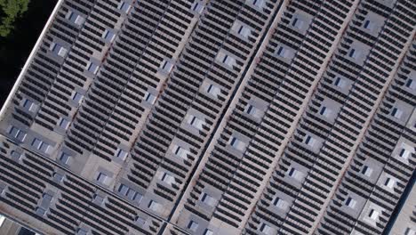 solar panels installed on a roof of a large industrial building or a warehouse. industrial buildings in the background. horizontal photo.