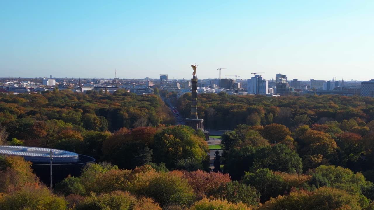 iconic berlin victory column rising above the vibrant autumn foliage of tiergarten park, with the cityscape in the background. Perfect aerial view flight fly reverse drone