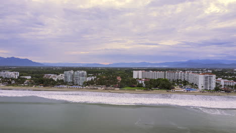 hyperlapse showcasing puerto vallarta's coastline, featuring the beach, hotels, lush green vegetation, and the hills of the mountain range in the background