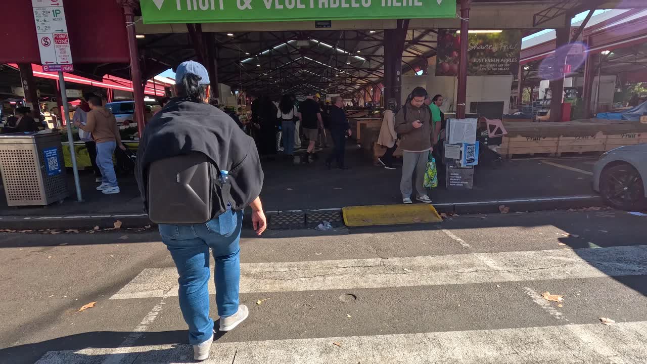 compradores caminando por el mercado de la reina victoria