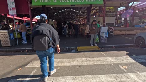 shoppers walking through queen victoria market