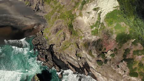 aerial-natural-landscape-of-Comans-Track,-Karekare,-New-Zealand-during-a-sunny-day-of-summer-trekking-walking-hiking-path-and-lonely-sand-beach-natural-unpolluted-paradise
