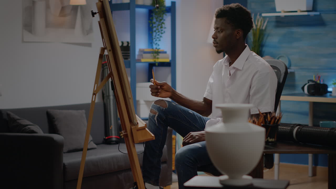 African american artist looking at vase for drawing design