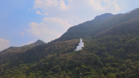 luang por khao, wat theppitak punnaram, imágenes aéreas inversas de 4k del famoso buda blanco gigante durante la tarde, sobrevuelo de pájaros, hermoso cielo con nubes dramáticas