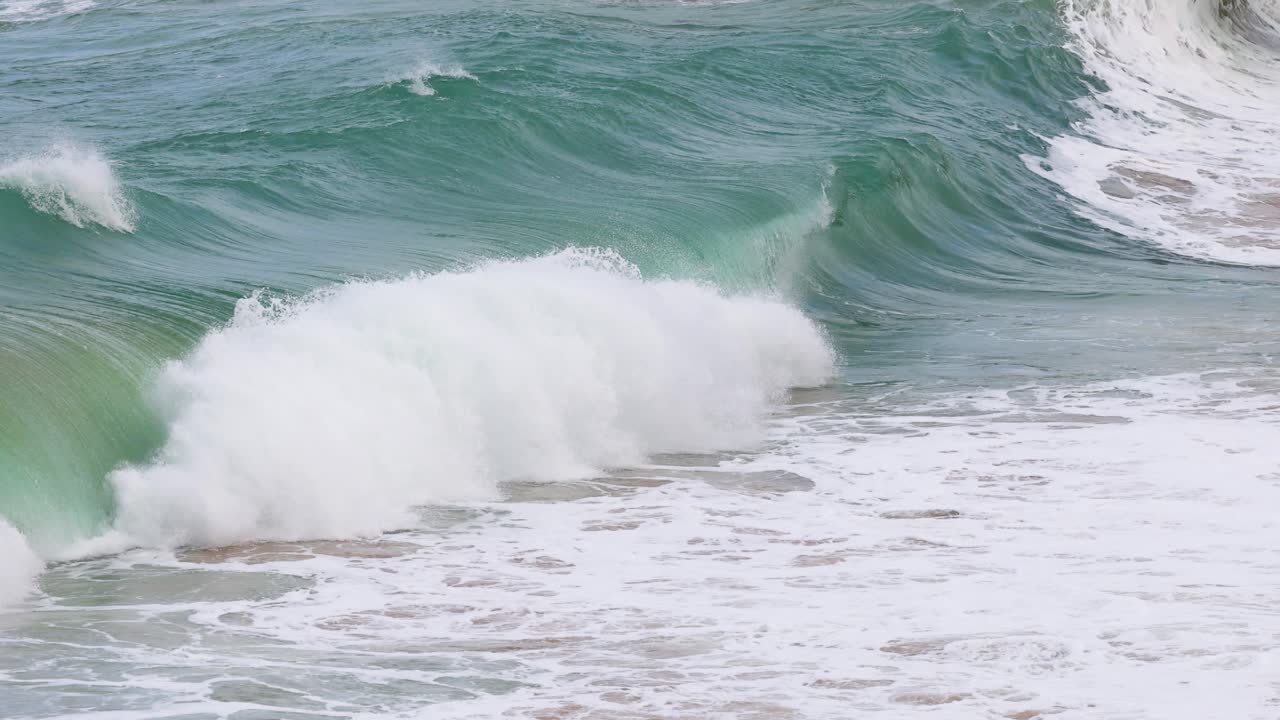Dynamic ocean waves crash against the shore at Port Campbell, Australia, captured in vibrant daylight with a focus on natural movement