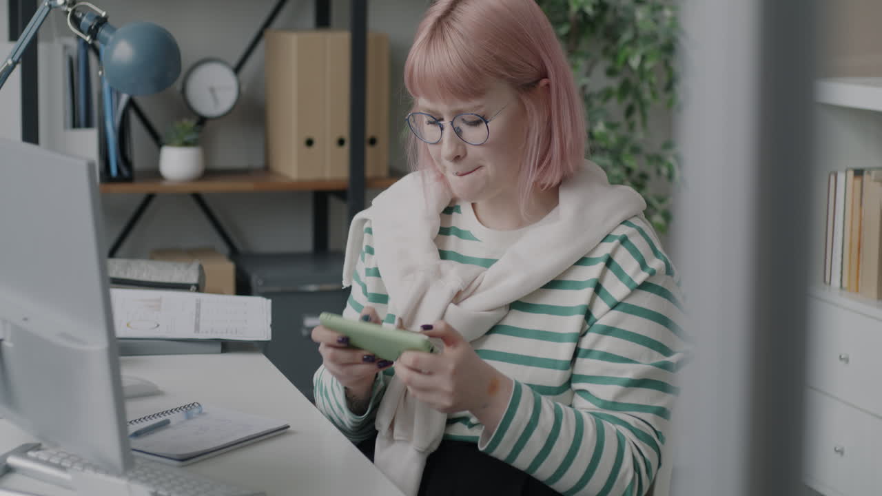 Woman Playing a Mobile Game in the Office