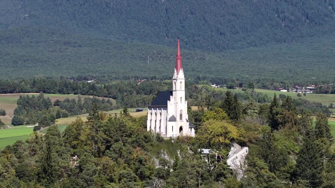 Vista aérea de drone da igreja de peregrinação Maria Locherboden acima de Mötz, no Tirol, Áustria, com o Vale do Inn e a paisagem alpina ao fundo