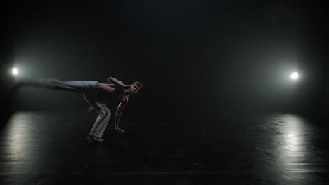 luchadores de capoeira realizando movimientos dinámicos en el escenario. artes marciales, danza y acrobacias en acción. atletas de pecho desnudo mostrando fuerza, flexibilidad y técnica bajo los reflectores