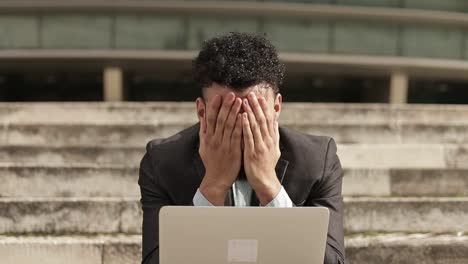 joven cansado y satisfecho trabajando con una computadora portátil