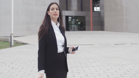 young woman taking a call using earplugs