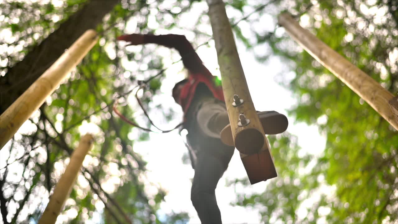 View of a woman at climbing adventure park in the Carpathians, greenery around, Romania. Slow motion