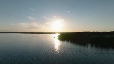 toma aérea de drones de barcos en un gran lago al atardecer