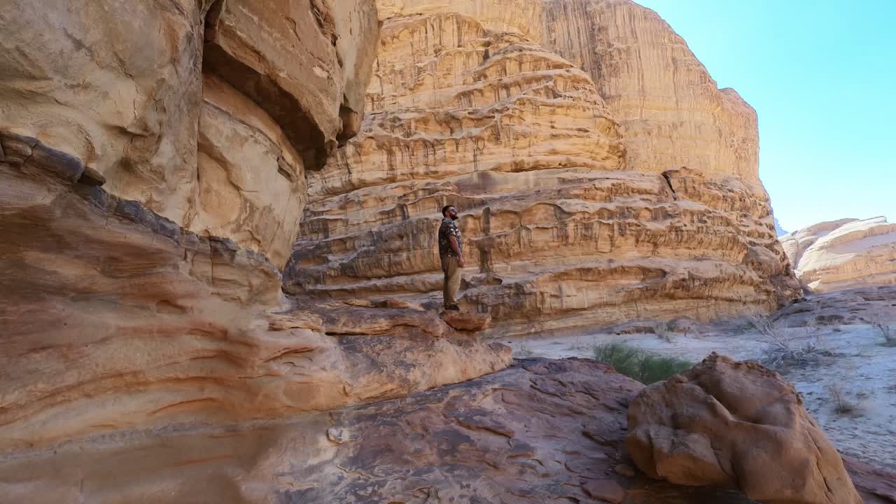 hombre asomado al acantilado en wadi rum