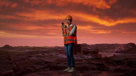 construction worker using smartphone at a quarry sunset